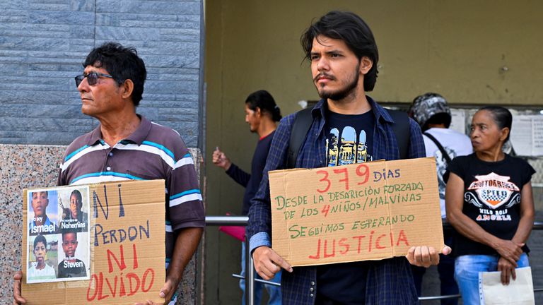 A protester holds a sign that reads: "379 days since the enforced disappearance of the 4 children. We are still waiting for justice". Pic: Reuters