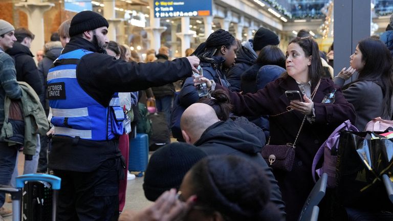 Eurostar sözcüsünün hizmetleri askıya aldıklarını söylemesinin ardından bir müşteri hizmetleri çalışanı yolcuya bir şişe su uzattı.