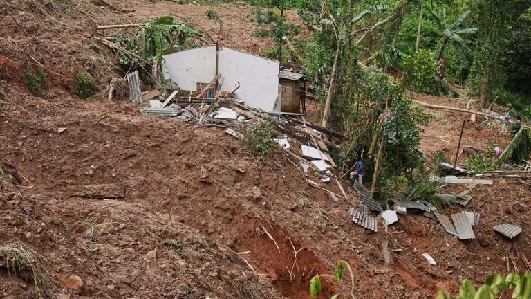 Osoby, które przeżyły osuwisko, ratują dobytek na miejscu osuwiska w wiosce Sarasavigama niedaleko Kandy na Sri Lance. Zdjęcie: AP