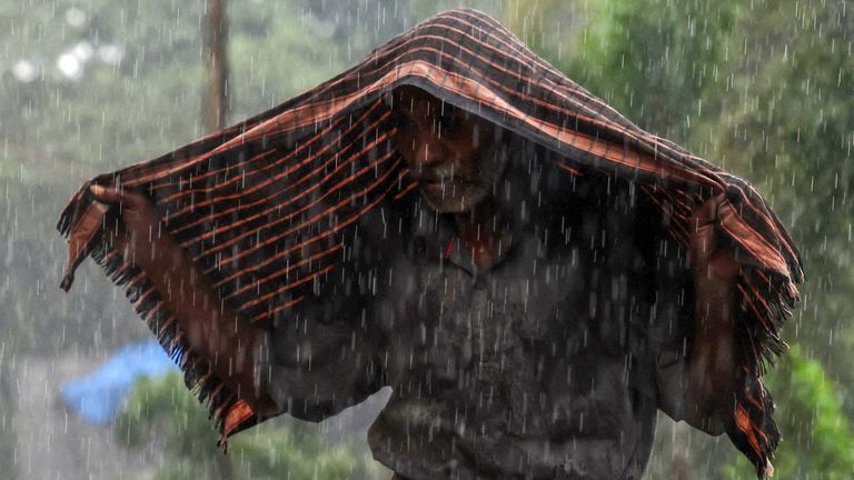 Mężczyzna chroni się szalikiem przed deszczem po cyklonie Ditwah w Chennai w Indiach. Fot: Reuters