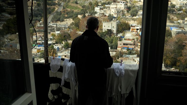 Zuhair al Rajabbi, artık yıkım alanlarıyla işaretlenmiş komşularının evlerine bakıyor