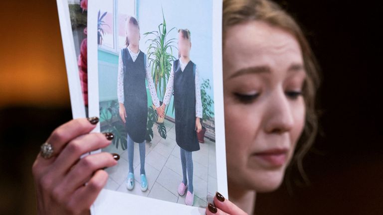 Kateryna Rashevska holding pictures said to show abducted Ukrainian children at the US Capitol last week. Pic: Reuters