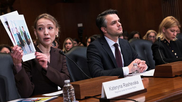 Kateryna Rashevska holding pictures said to show abducted Ukrainian children at the US Capitol last week. Pic: Reuters