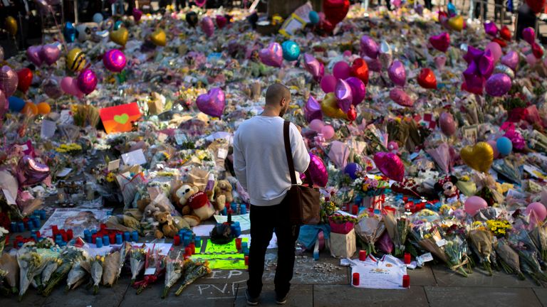 A man stands next to flowers for the victims in May 2017. Pic: AP