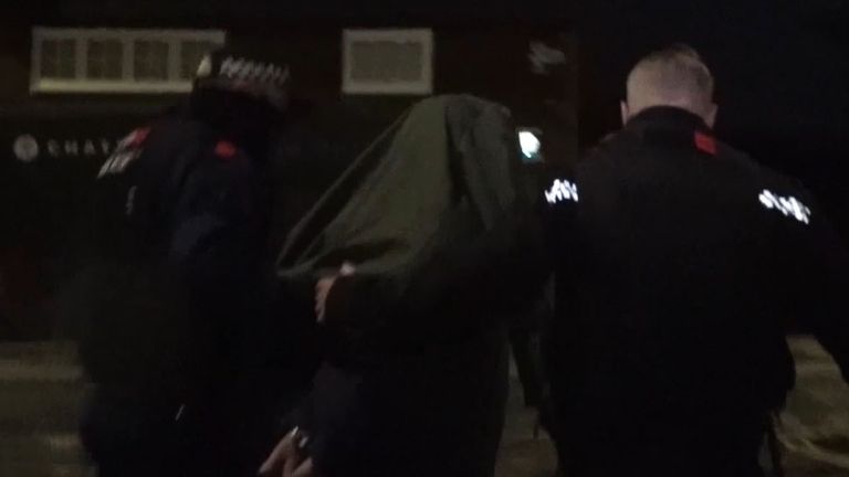 Podejrzany zostaje wyprowadzony po zatrzymaniu w Prescot. Zdjęcie: NWROCU/PA