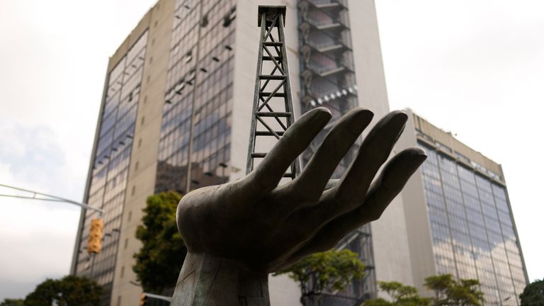 A sculpture of a hand holding an oil well outside state-run oil company Petroleos de Venezuela. Pic: AP