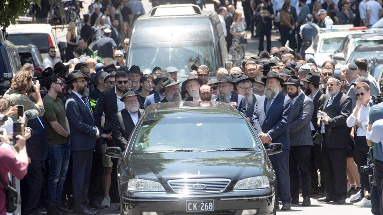 Mourners attend the funeral of Rabbi Eli Schlanger. Pic: Reuters