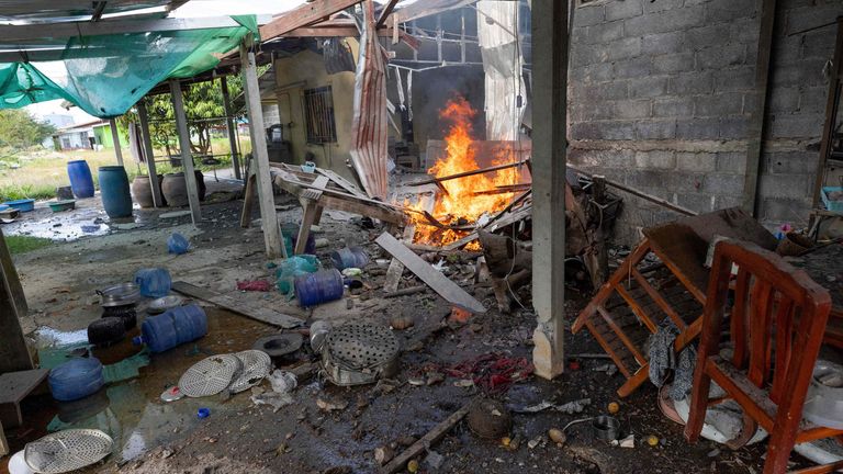 Flame rises from a house which, Thai local security forces say, was damaged by a Cambodian artillery strike in Surin province, Thailand, on 11 December. Pic: AP