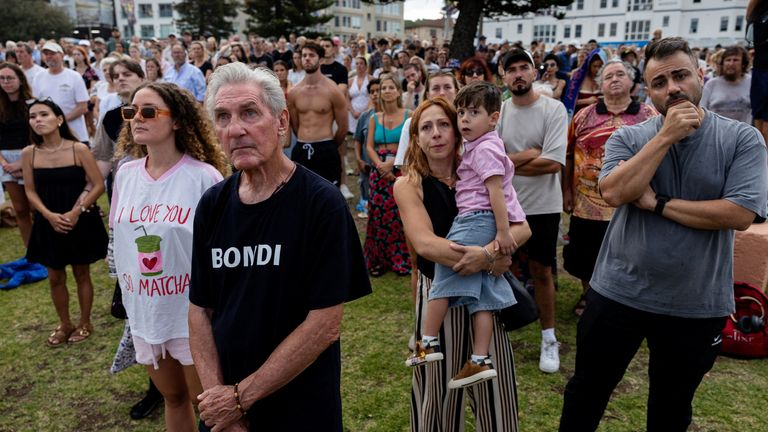People observe a moment of silence at Bondi Beach