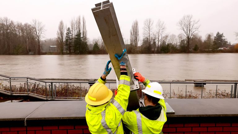 'Catastrophic', life-threatening, floods hitting Washington State, USA 2 Mount Vernon city employees install a flood wall in downtown Mount Vernon, Washington. Pic: The Seattle Times/AP