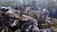 People stand near the wreckage of a plane crash in Playa de Belen, North Santander Colombia.
Pic:Notiplaya/Reuters