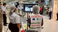 Airport health authorities wearing protective masks monitor passengers from international flights arriving at Suvarnabhumi International Air
