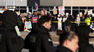 Demonstrators hold placards outside the venue where U.S. President Donald Trump delivers a speech on energy and the economy, in Clive, Iowa,