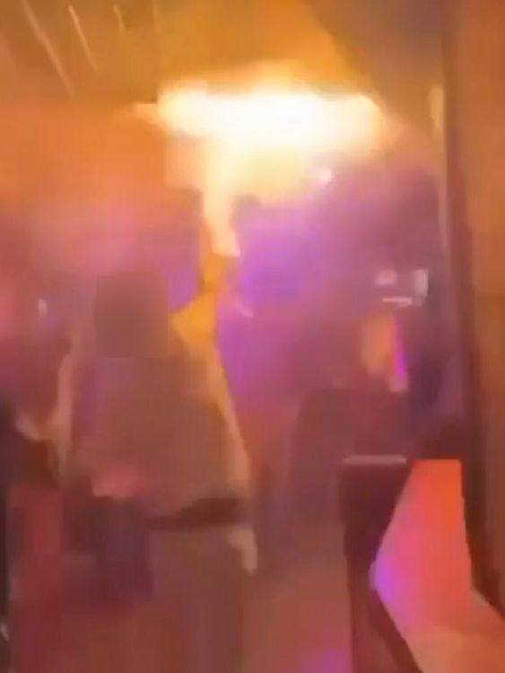 Someone is seen trying to put out the flames with a white shirt in footage widely shared online