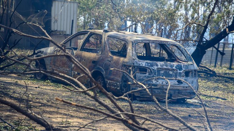 Orman yangınları sırasında yanmış bir araba bir mülkte duruyor. Resim: AAP/Reuters