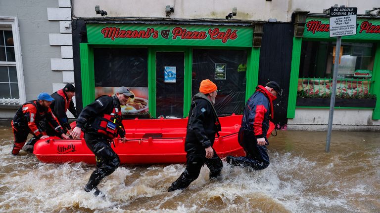A search and rescue team walk with a boat through a flooded street, after the River Slaney burst its banks.
Pic: Reuters