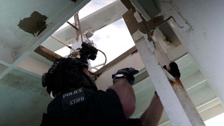 The police systematically search the ship to find the mock attackers