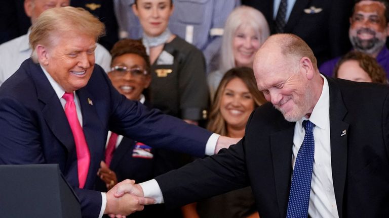 Trump and Homan shaking hands at an event last year. Pic: Reuters