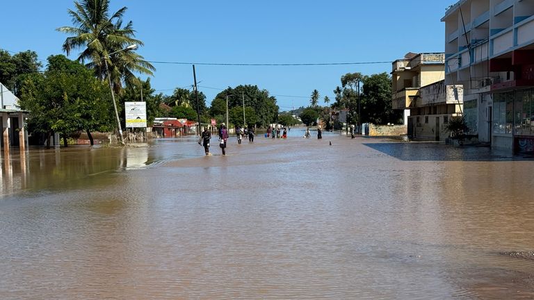People wade through the floodwaters