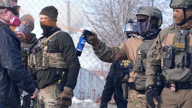 An Immigration and Customs Enforcement (ICE) agent sprays pepper spray at a protester in Minneapolis. Pic: AP