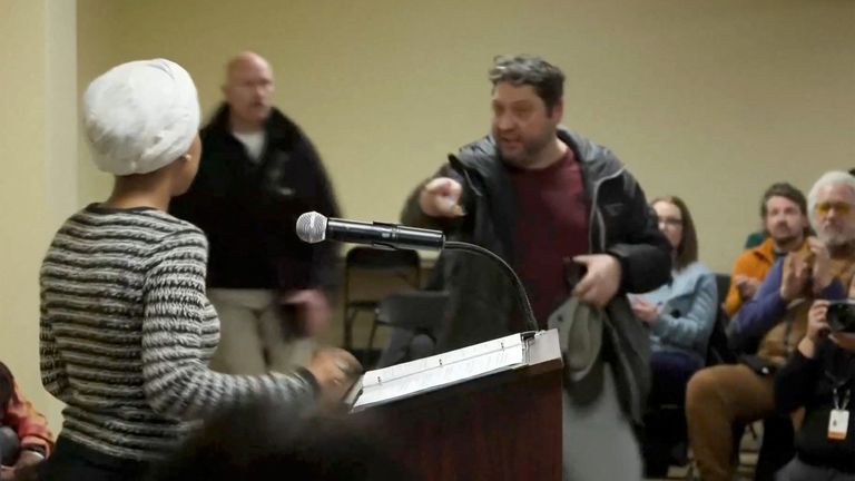 Bir adam belediye binasında İlhan Omar'a ilaç sıktıktan sonra ona bağırıyor. Resim: Reuters/Maria Alejandra Cardona