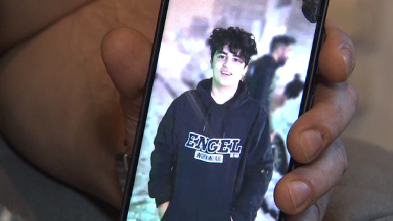 Amir Ali Haydari's cousin shows us a photo of his cousin.