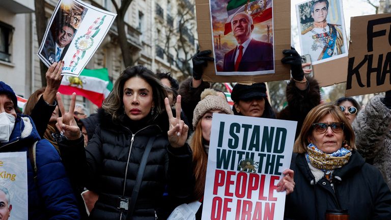 A person holds a picture of Reza Pahlavi in Paris. Pic: Reuters