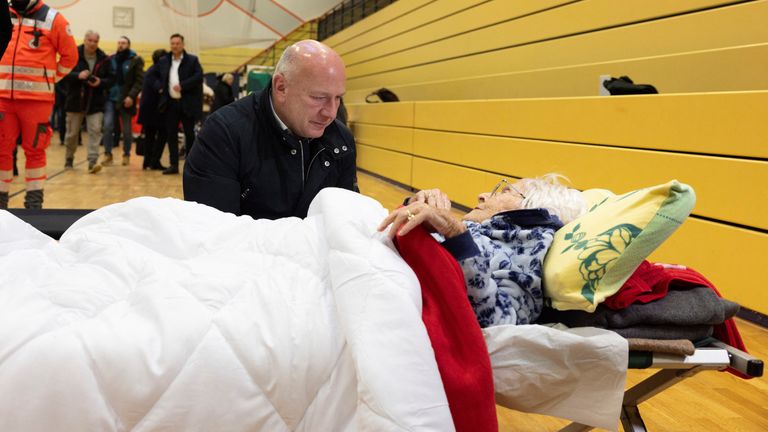 Berlin's Mayor Kai Wegner meeting an elderly woman at emergency accommodation. Pic: Reuters