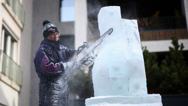 An ice sculptor works on decorations for the upcoming Winter Olympics and Paralympics in Italy. Pic: Reuters 