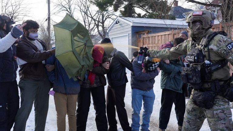Minneapolis'te bir araç sürücüsünün vurulmasının ardından bir federal ajan, caddeyi kapatan protestoculara biber gazı sıktı. Resim: Reuters