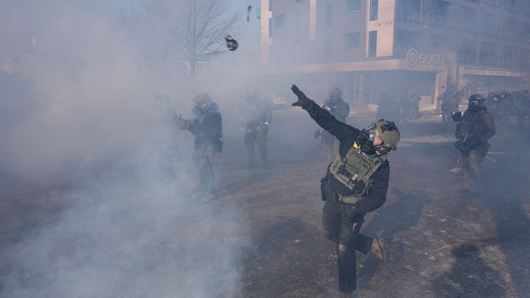 A federal agent throws a crowd-control weapon. Pic: Reuters