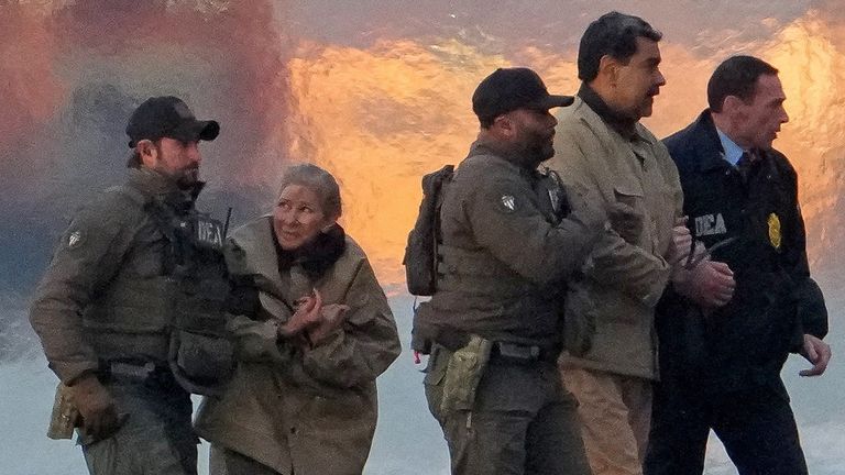 Nicolas Maduro and wife Cilia Flores are escorted out of a helicopter. Pic: Reuters