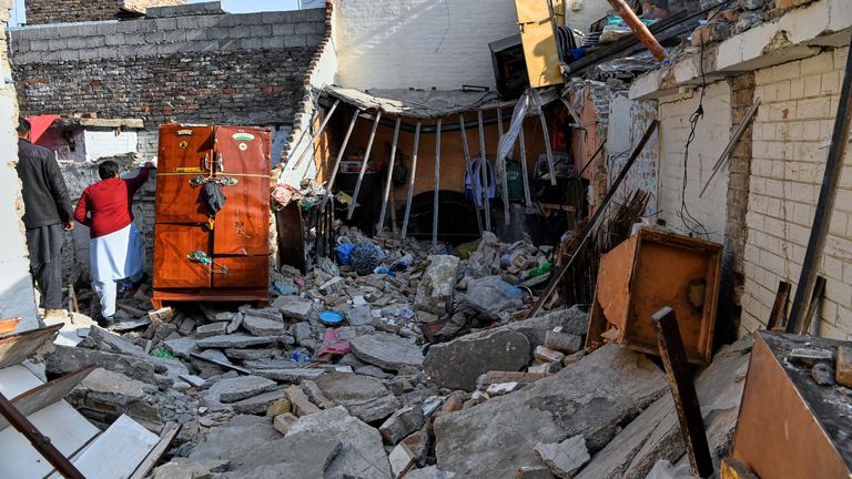 Officials survey the damage of the home hit by the explosion. Pic: AP