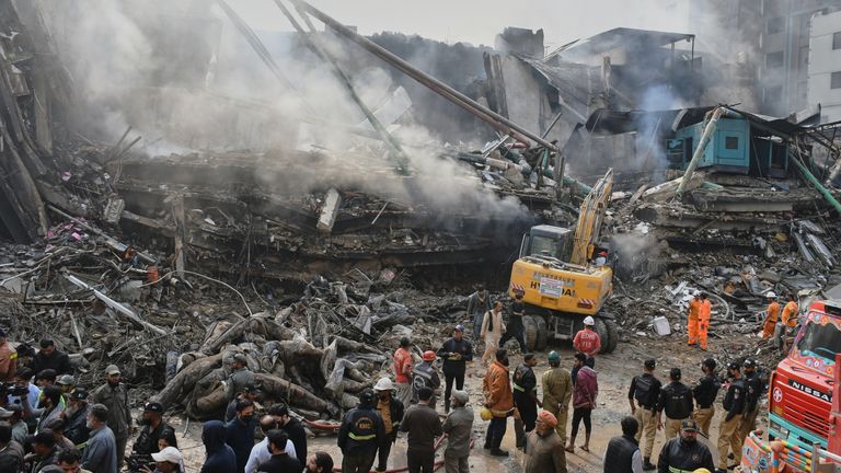 Redders gebruiken zware machines om door het puin te zoeken. Foto: AP