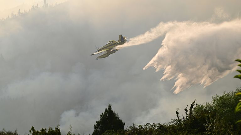 A plane drops water on to wildfires in El Hoyo, Patagonia, Argentina. Pic: AP
