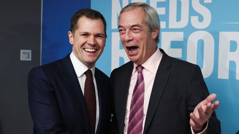 Former British Conservative Party member Robert Jenrick shakes hands with Reform UK leader Nigel Farage at a press conference, as Jenrick ha