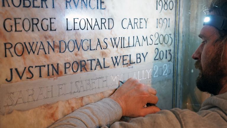 Stonemason Benn Swinfield inscribes the name of the new Archbishop of Canterbury Dame Sarah Mullally onto a plaque. Pic: PA
