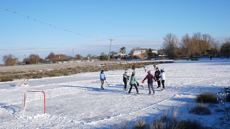 İnsanlar Cambridgeshire'da sular altında donmuş bir sahada buz hokeyi oynuyor. Resim: PA