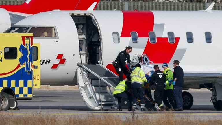 Medical staff and airport personnel take a casualty onto a Swiss Air-Ambulance plane. Pic: Reuters