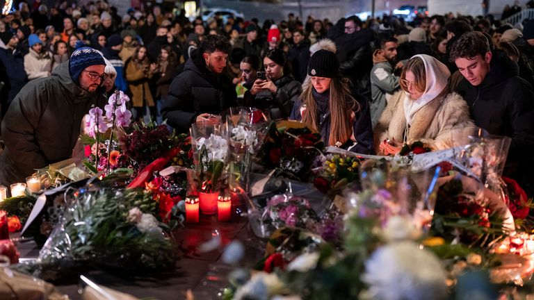 Yas tutanlar çiçek bırakmak için toplandılar. Resim: AP