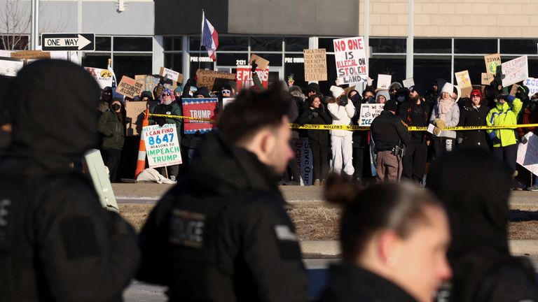 Demonstrators hold placards outside the venue. Pic: Reuters