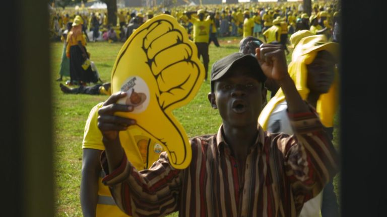 Um homem segura um dedo de espuma e o transforma em um polegar para baixo.