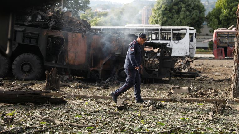 Bir itfaiyeci, La Carlota askeri hava üssünde tahrip edilmiş bir uçaksavar biriminin yanından geçiyor. Resim: Reuters