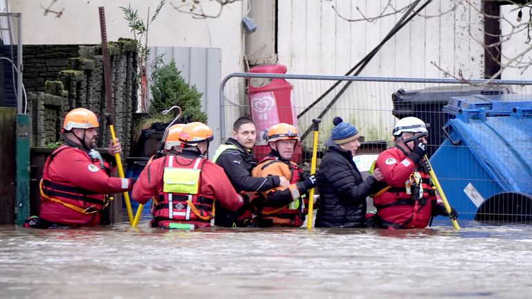 People are escorted through flood waters in Enniscorthy, Co Wexford.  
Pic: PA