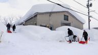 People clear snow in Aomori, northern Japan. Special taskforces have been sent to the worst hit areas. Pic: Associated Press