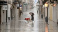 People walk in a shopping area amid rain as storm Leonardo hits parts of Spain, in Ronda.
Pic: Reuters