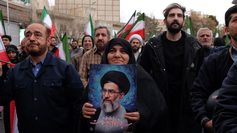 A woman holds a picture of the Supreme Leader Ayatollah Ali Khamenei during a demonstration in support of the government. Pic: AP