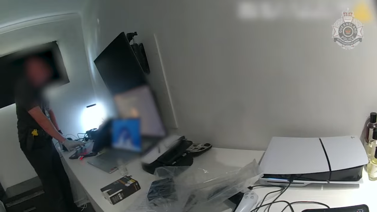 Nagranie z kamery noszonej na ciele, przedstawiające funkcjonariuszy przejmujących dowody w ramach śledztwa. Zdjęcie: Policja w Queensland