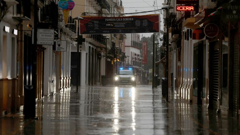 A police car patrols an empty shopping area in Ronda. Pic: Reuters