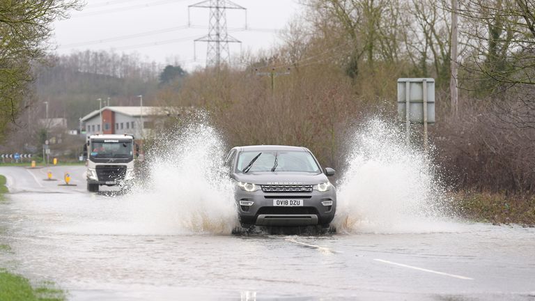 一辆汽车驶过莱斯特郡芒特索雷尔附近一条被洪水淹没的道路。图片：PA